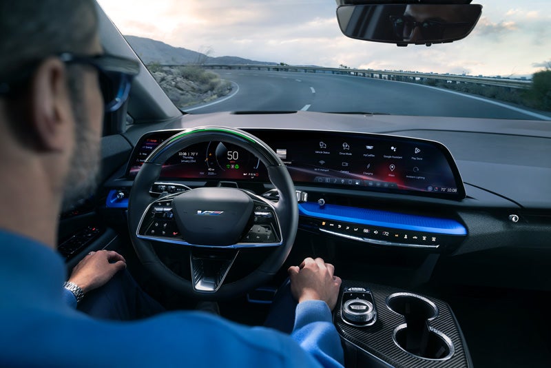 Front View of the 2026 OPTIQ-V Driving Through the Dusk Utilizing its Headlights | Swickard Cadillac Anchorage in Anchorage AK